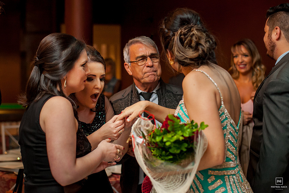 Amigas olhando anel de noivado de formanda