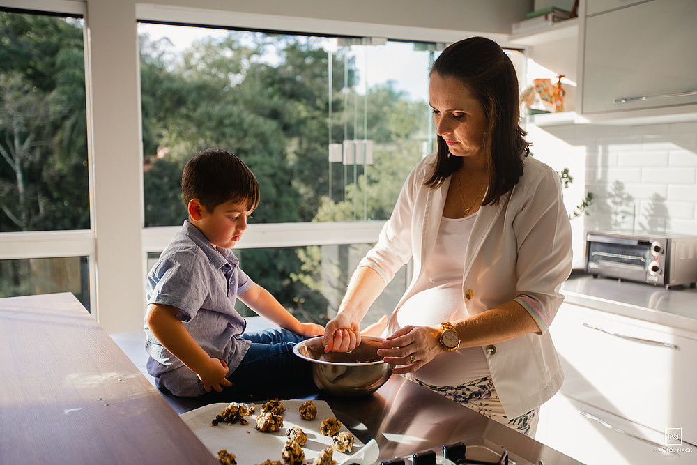 mae gravida cozinhando com filho mais velho