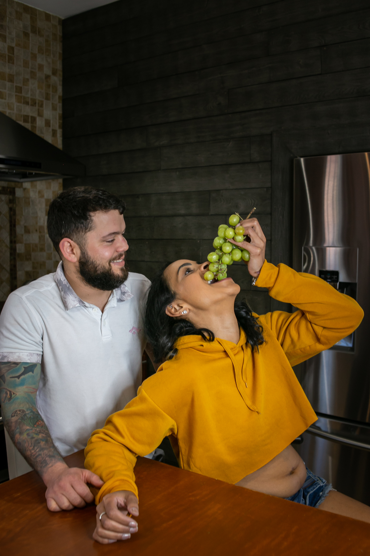 ensaio fotográfico gestante, pregnany, maternity, realizado na casa do cliente, ensaio em casal anunciando gravidez, ensaio mais intimista, fotografado por Cinthia Toledo Fotografia. comendo uva, fruta, 