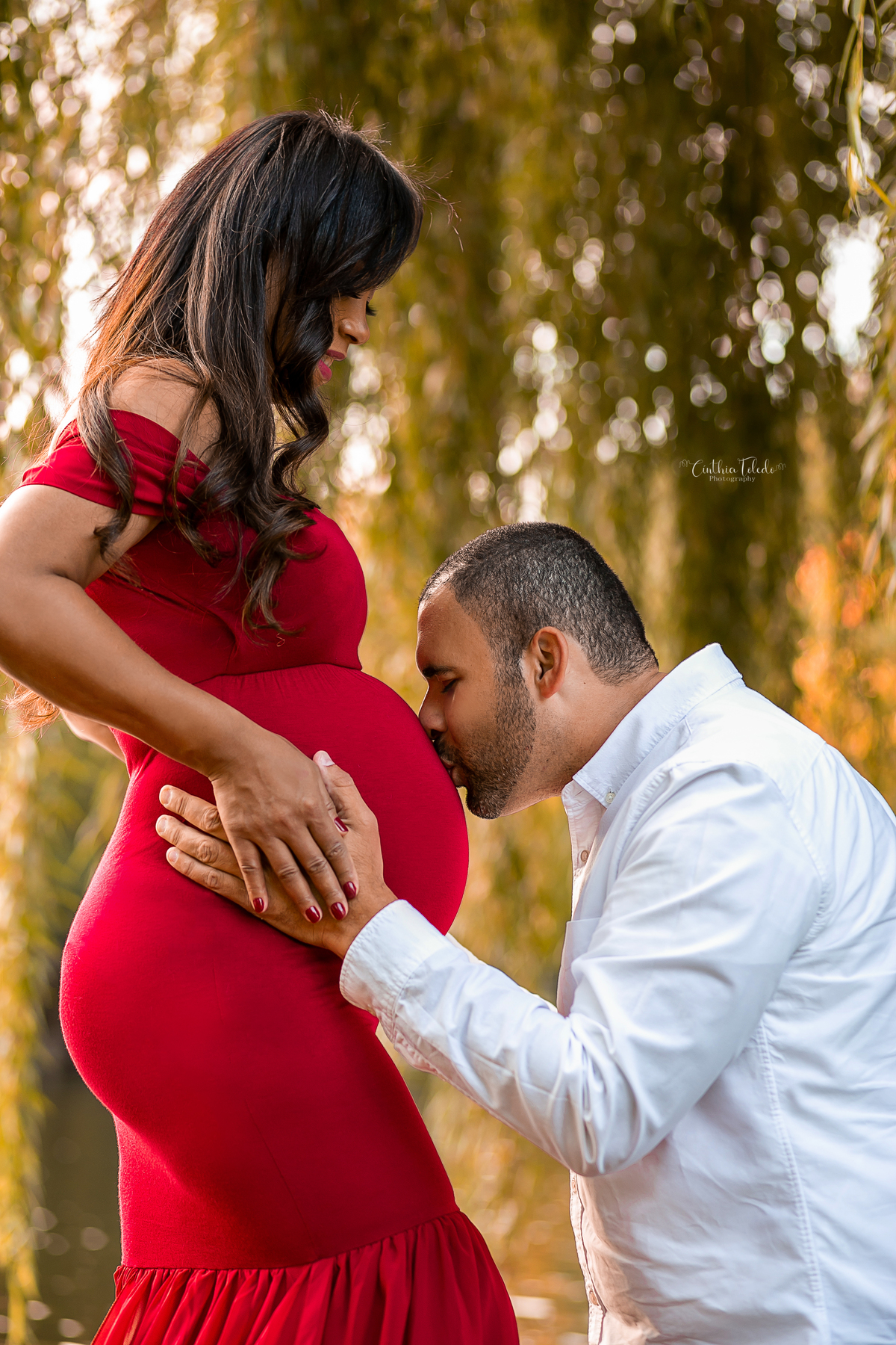 ensaio fotográfico gestante realizado no park street de Boston-MA, fotógrafa Cinthia Toledo Fotografia, fotógrafa de Gestante e Família em Massachusets. Pregnancy, maternity, vestido vermelho, beijando barriga, casal