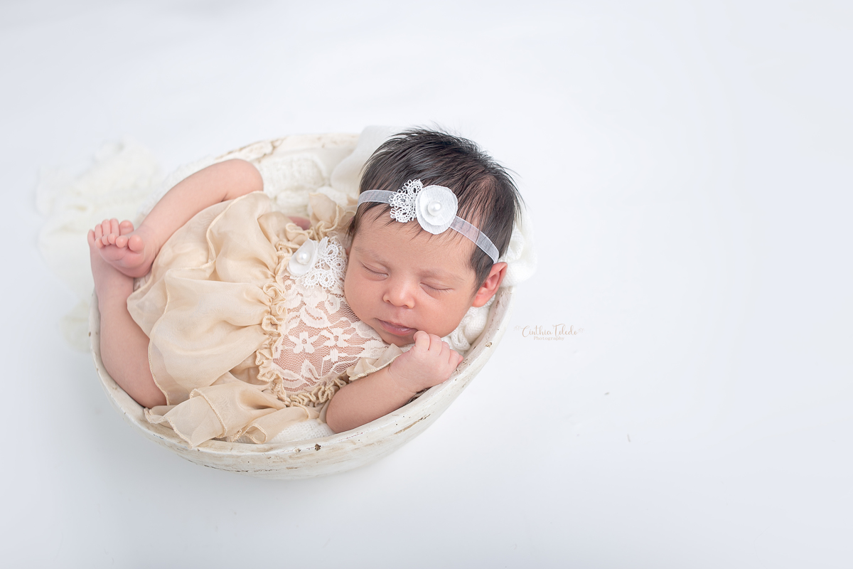 Ensaio fotográfico de Newborn / recém-nascido realizado em home-studio, localizado em Malden-MA, fotografado pela fotógrafa Cinthia Toledo Photography/fotografia.  Foto newborn na gamela de vestido e barriguinha para cima.