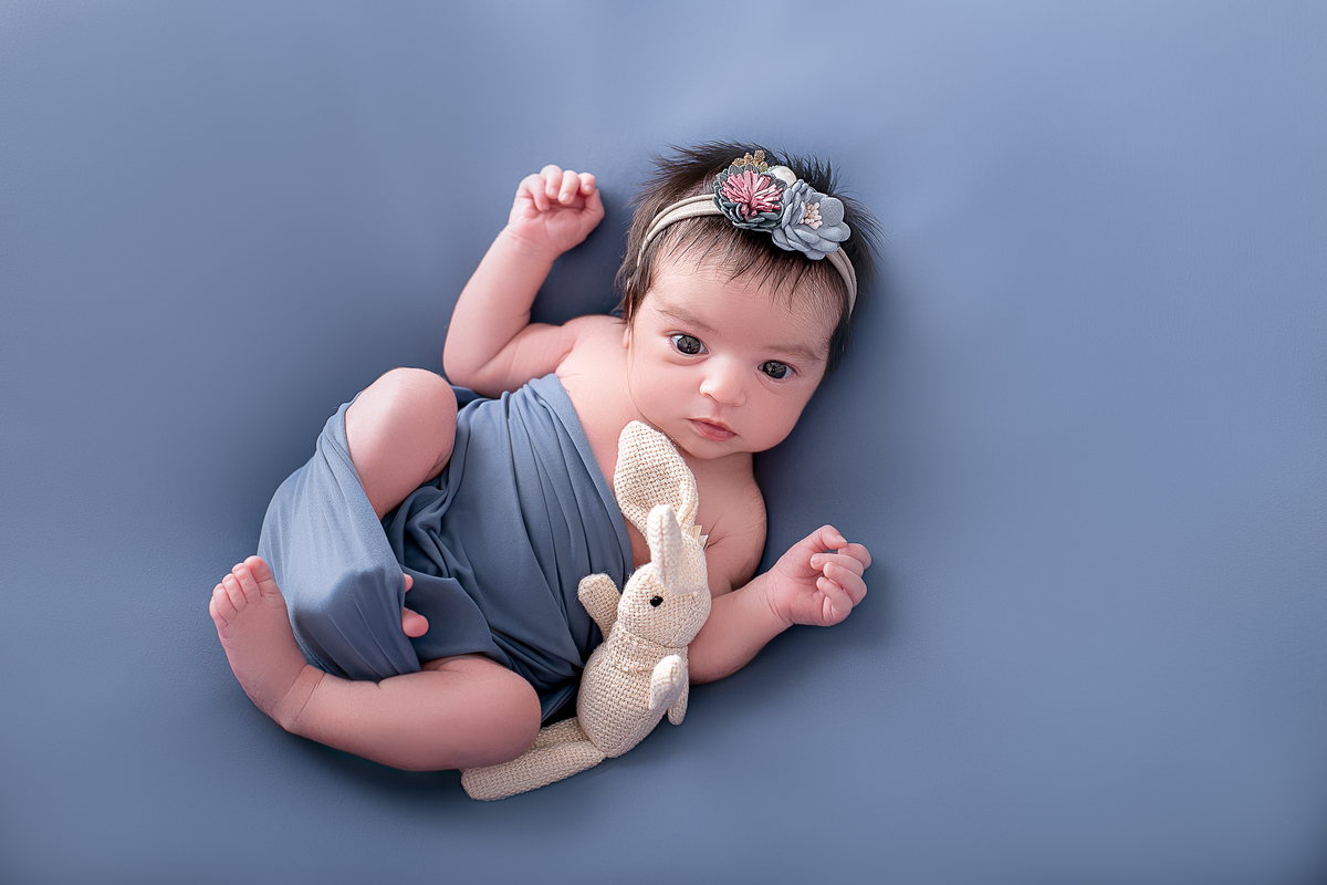 ensaio newborn feminino, fotografado por Cinthia Toledo photography/fotografia, Fotógrafa de Família especializada em newborn, fotografado em Malden-MA EUA. pose barruiguinha pra cima, pose no puff, cor azul.