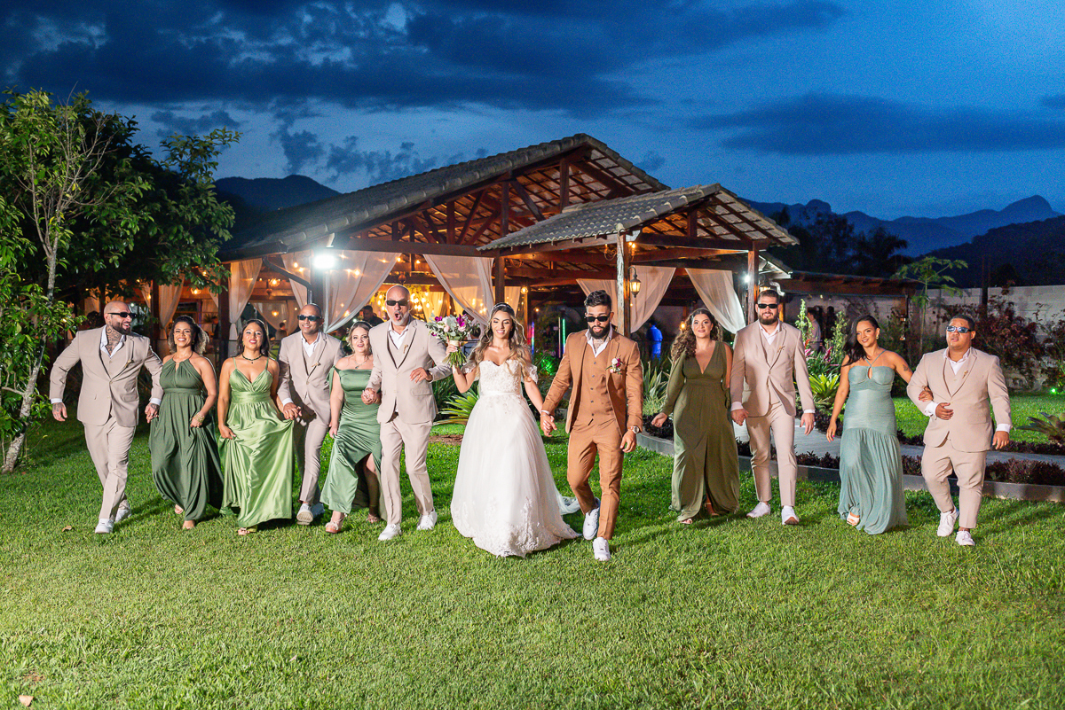 Noivos com padrinho no campo 