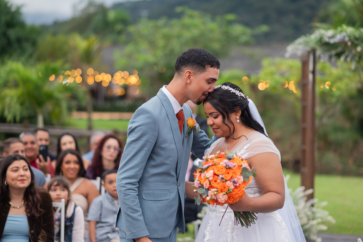 Noivo beijando a testa da noiva 