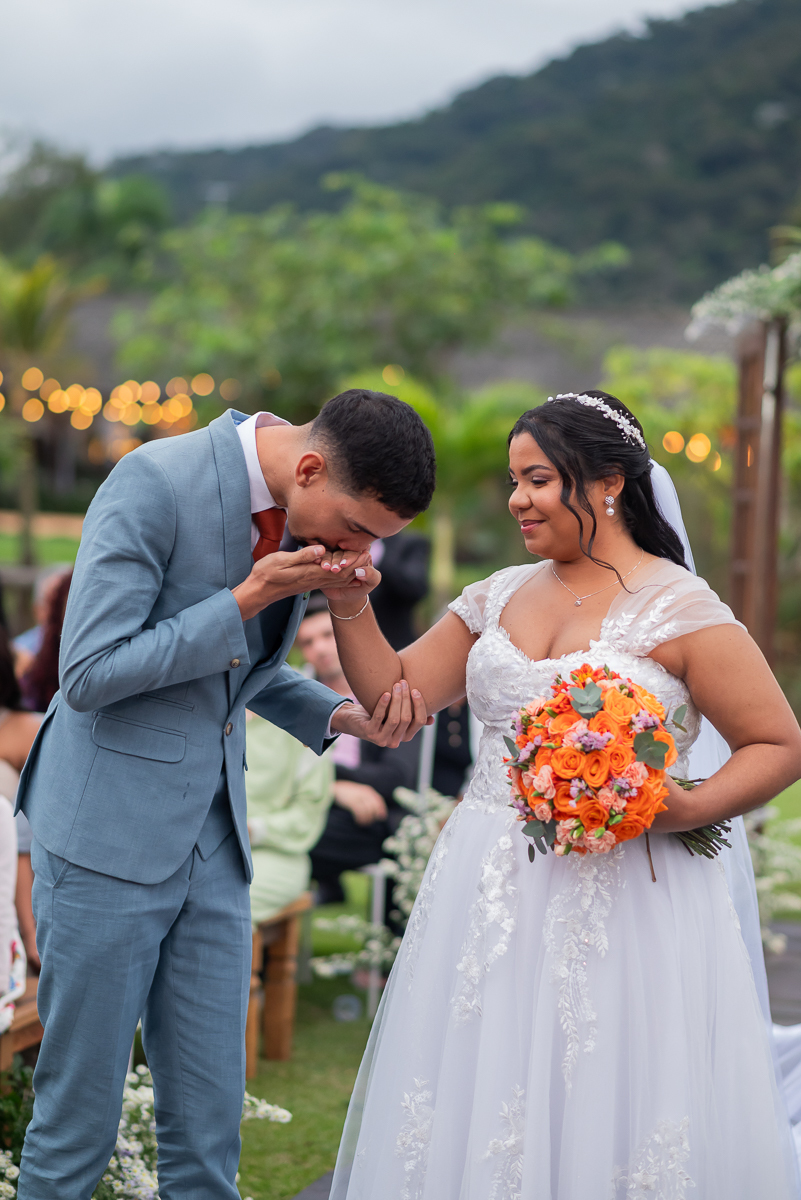 Noivo beijando a mão das noivos 