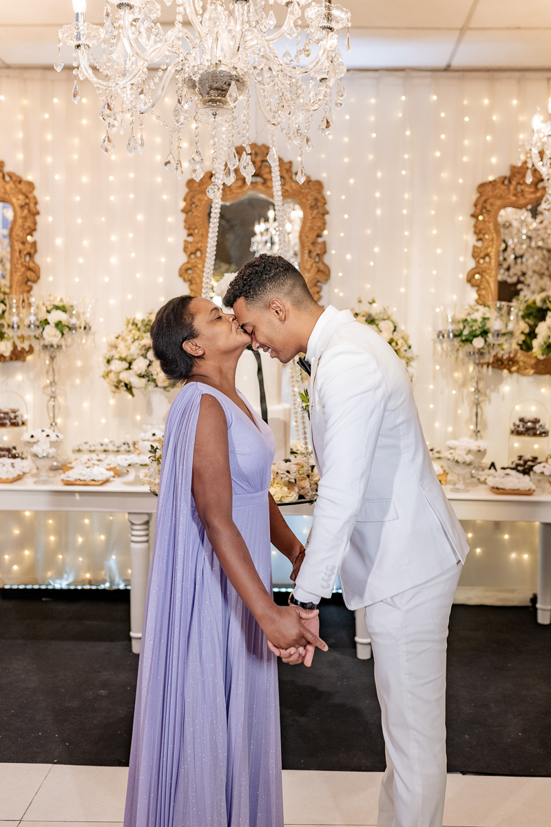 Noivo com a mãe na mesa do bolo