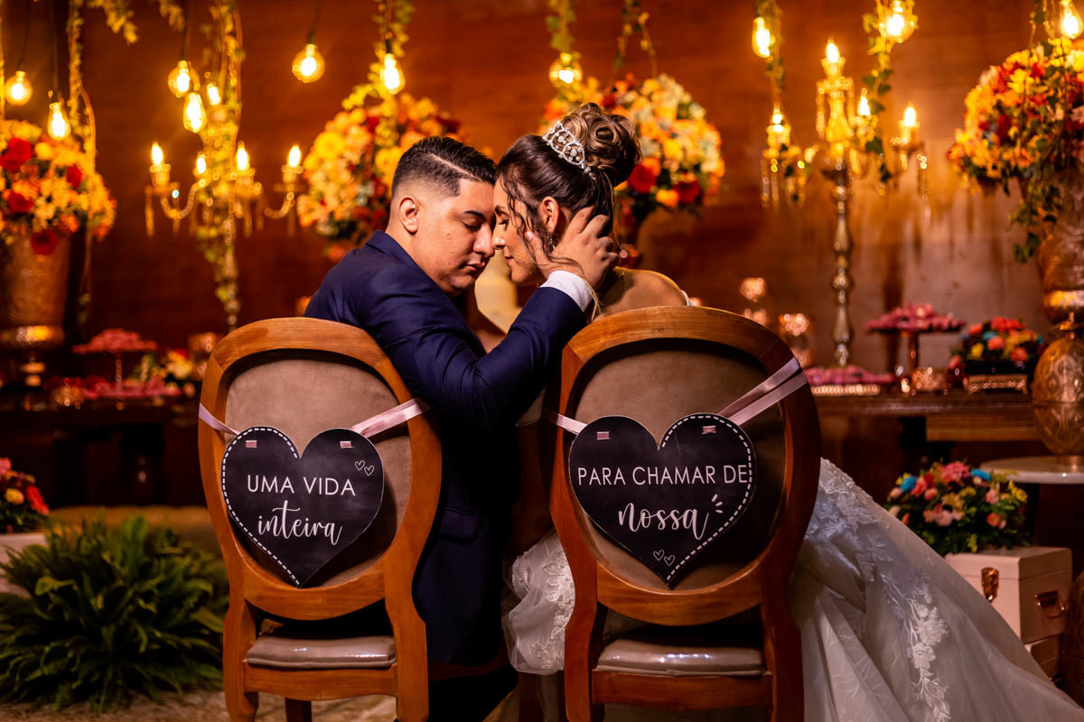 foto dos noivos na cadeira com plaquinha