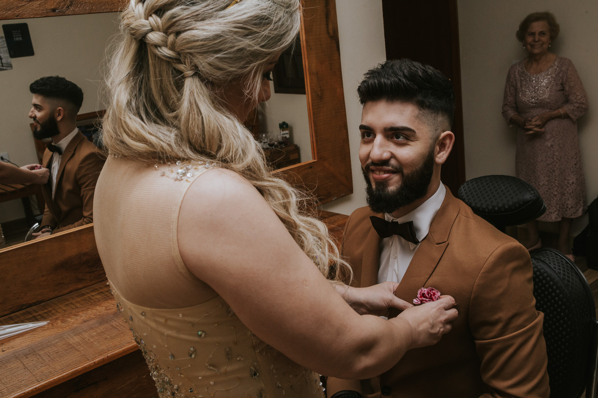mãe colocando a flor de lapela dia do noivo Espaço Verde casamento Millena e Esthevan