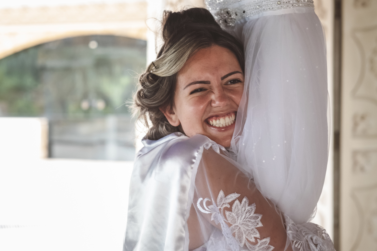 Dia da noiva Juliane abraçando o vestido Monte Castelo Eventos