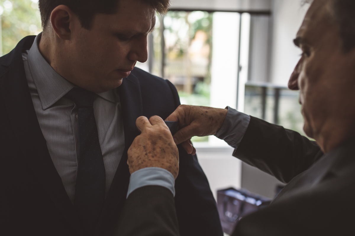 Making of do noivo pai ajustando o terno no filho