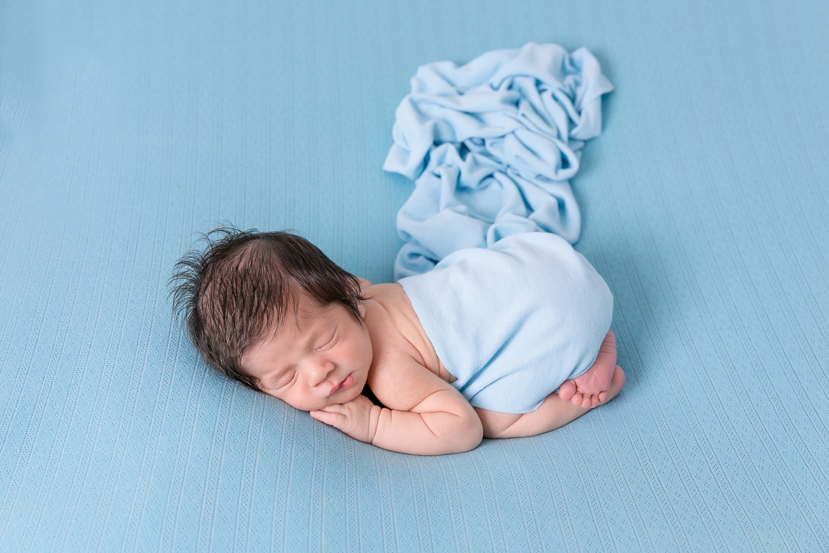 ensaio newborn menino, bebe com  manta azul, pose de bundinha , bebe com warp  newborn em santos newborn na baixada melhores fotografos de santos 