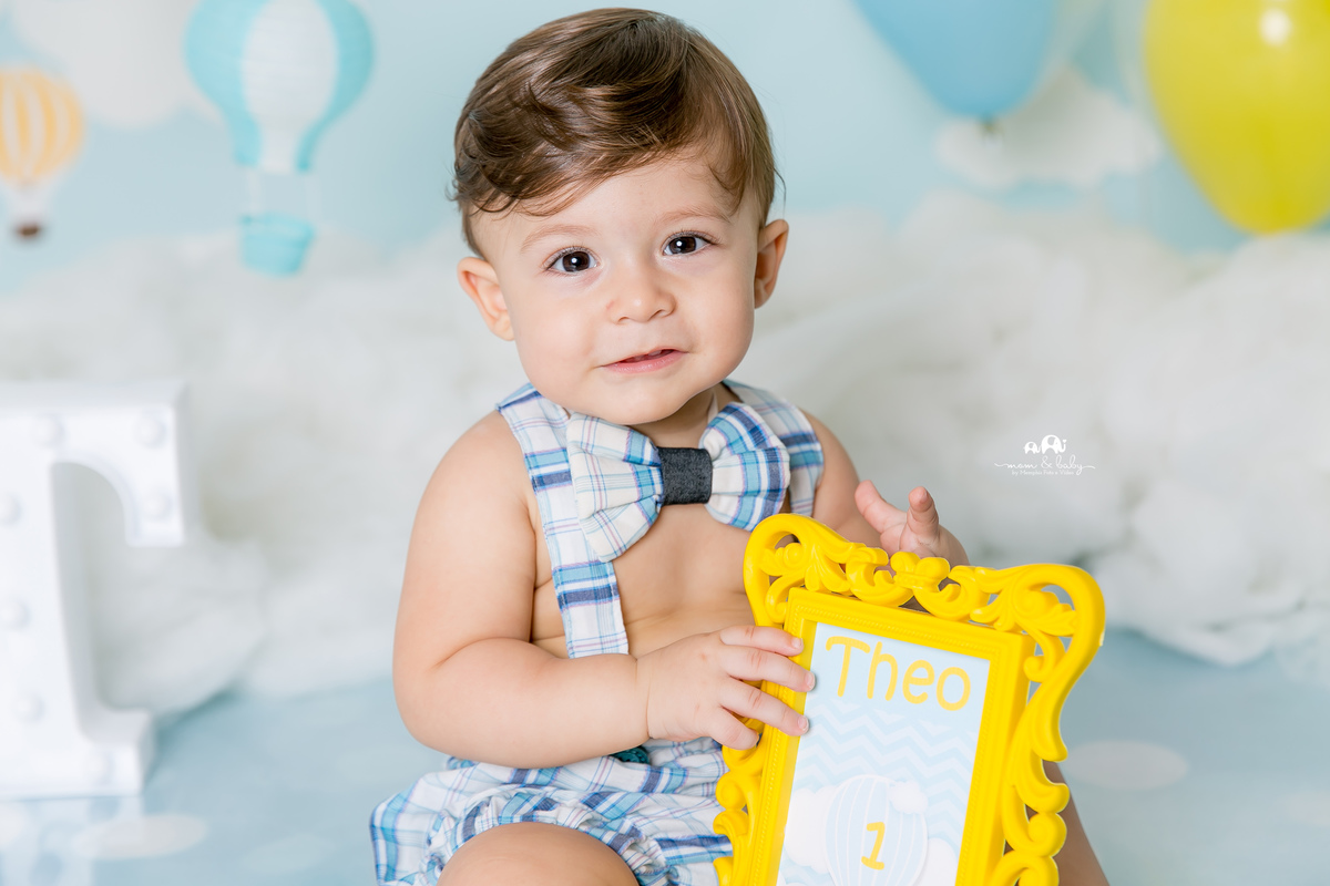 ensaio smash the cake em santos, fotografas de santos,ensaio estudio.smash clean,estudio fotografico em santos,ensaio com bolo jo farah leticia farah,mom and baby santos,smash de baloes,amarelo e azul,suspensorio e gravata borboleta, nuvens de eva,menino