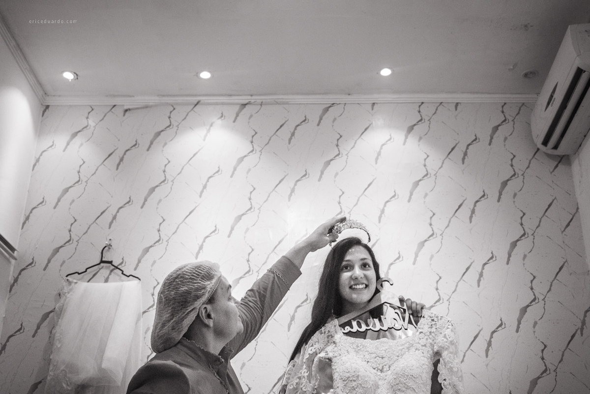 Noiva se olhando no espelho enquanto coloca coroa