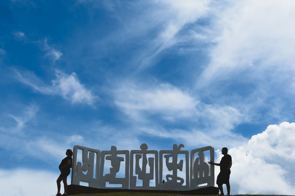 Fotografia de silhueta do casal junto com a escultura em Campos do Jordão - ensaio de gestante - Cia P&B - Fotografia
