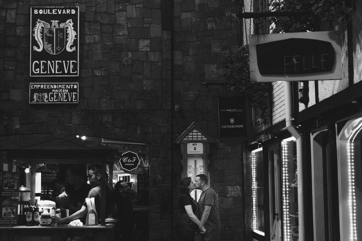 Fotografia do beijo do casal de mãos dadas no centro de Campos do Jordão durante ensaio de gestante - Cia P&B - Fotografia