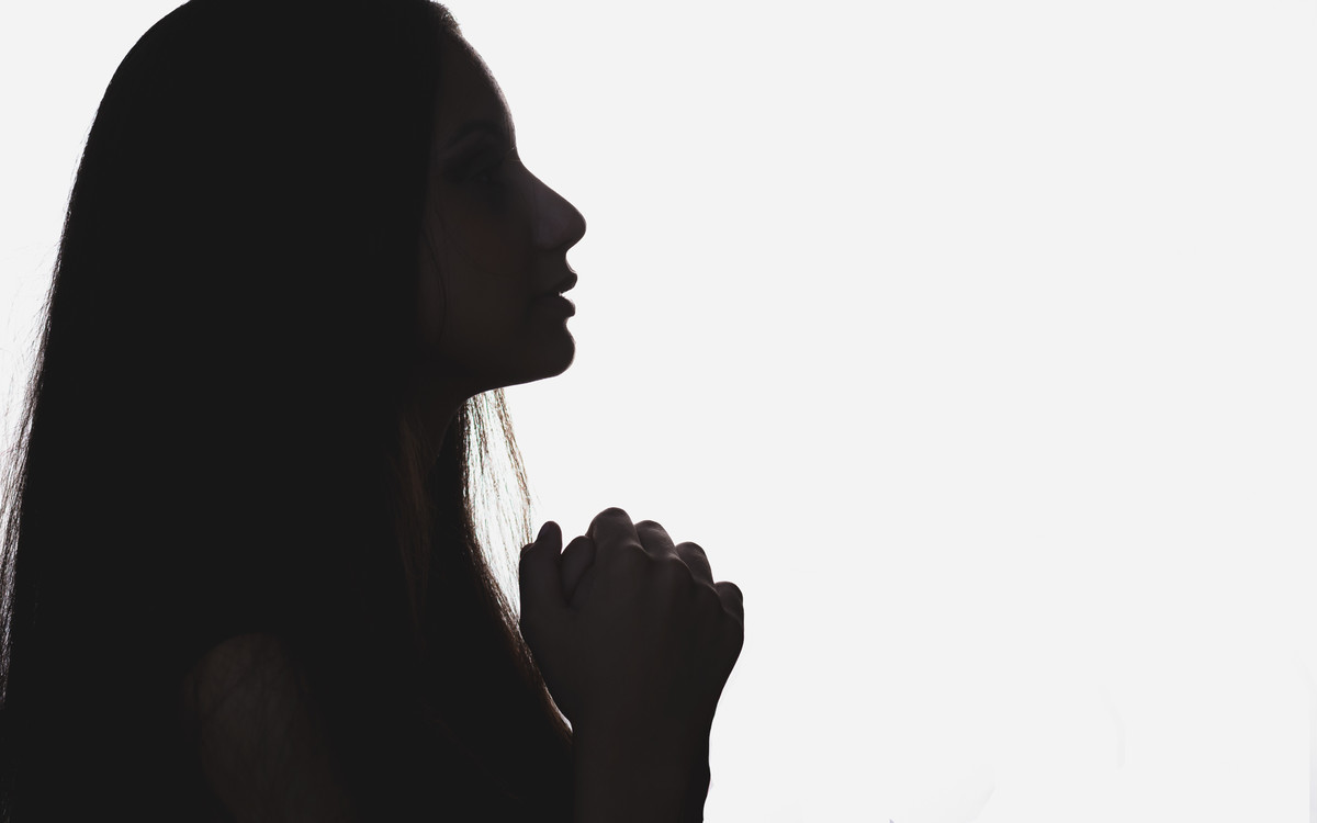 Fotografia da debutante de perfil com as mãos entrelaçadas contra luz - ensaio de 15 anos - Cia P&B - Fotografia