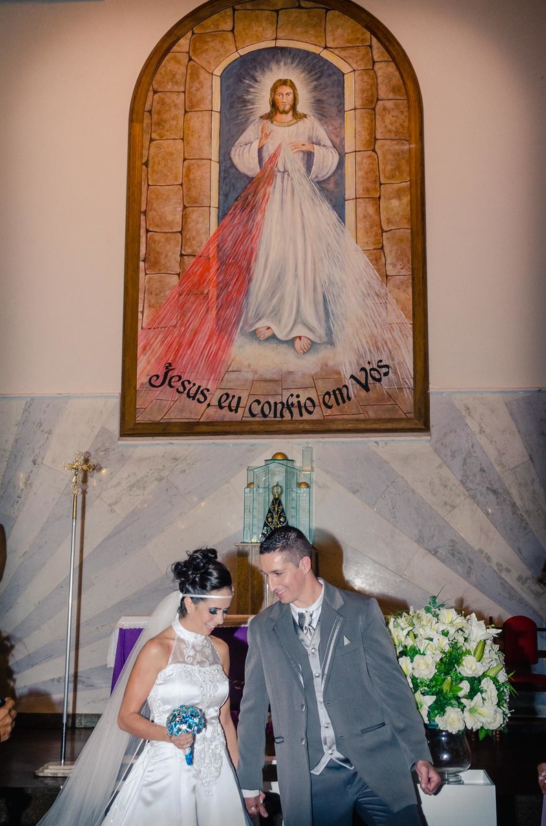 Fotografia dos noivos de mãos dadas no altar durante o casamento na igreja Paróquia Nossa Senhora Aparecida em Mongaguá - Cia P&B - Fotografia