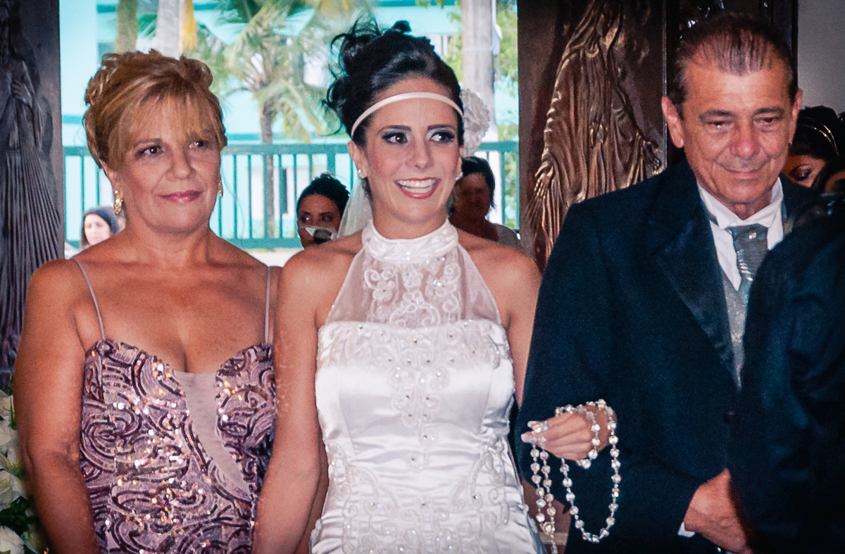 Entrada da noiva com seu pai e sua mãe durante o casamento na igreja Nossa Senhora Aparecida em Mongaguá - Cia P&B - Fotografia 