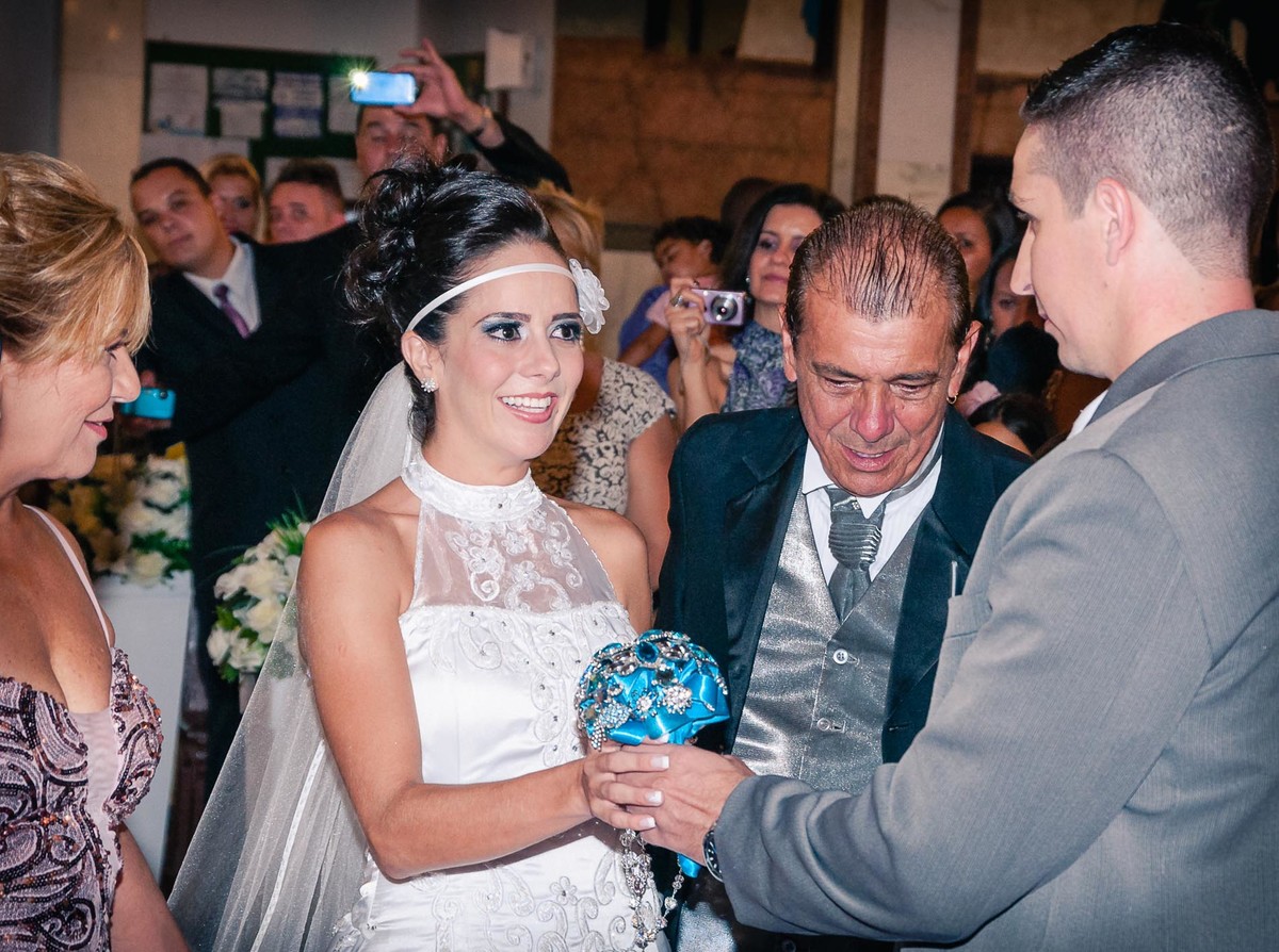 Fotografia dos pais entregando a noiva para o noivo durante o casamento na igreja Nossa Senhora Aparecida em Mongaguá - Cia P&B - Fotografia