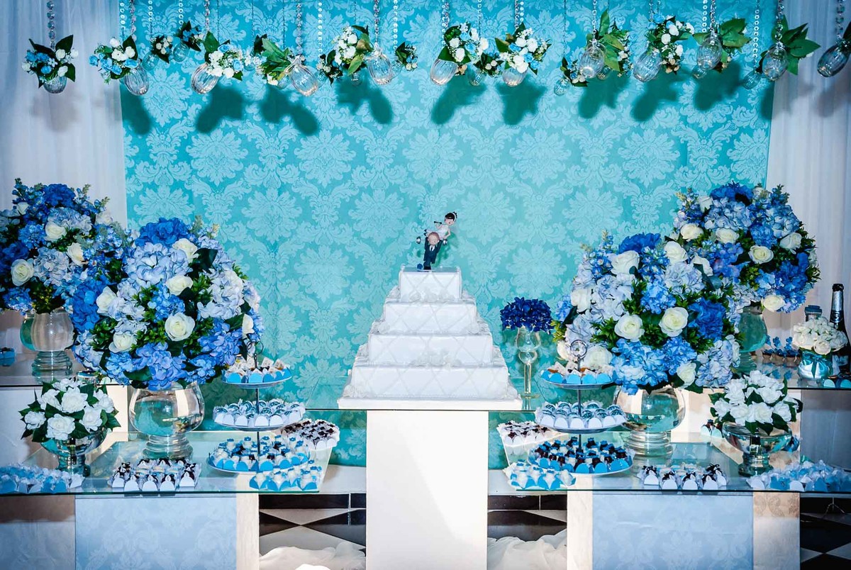 Fotografia da decoração da mesa do bolo durante a festa de casamento no Buffet Laranja em Mongaguá - Cia P&B - Fotografia