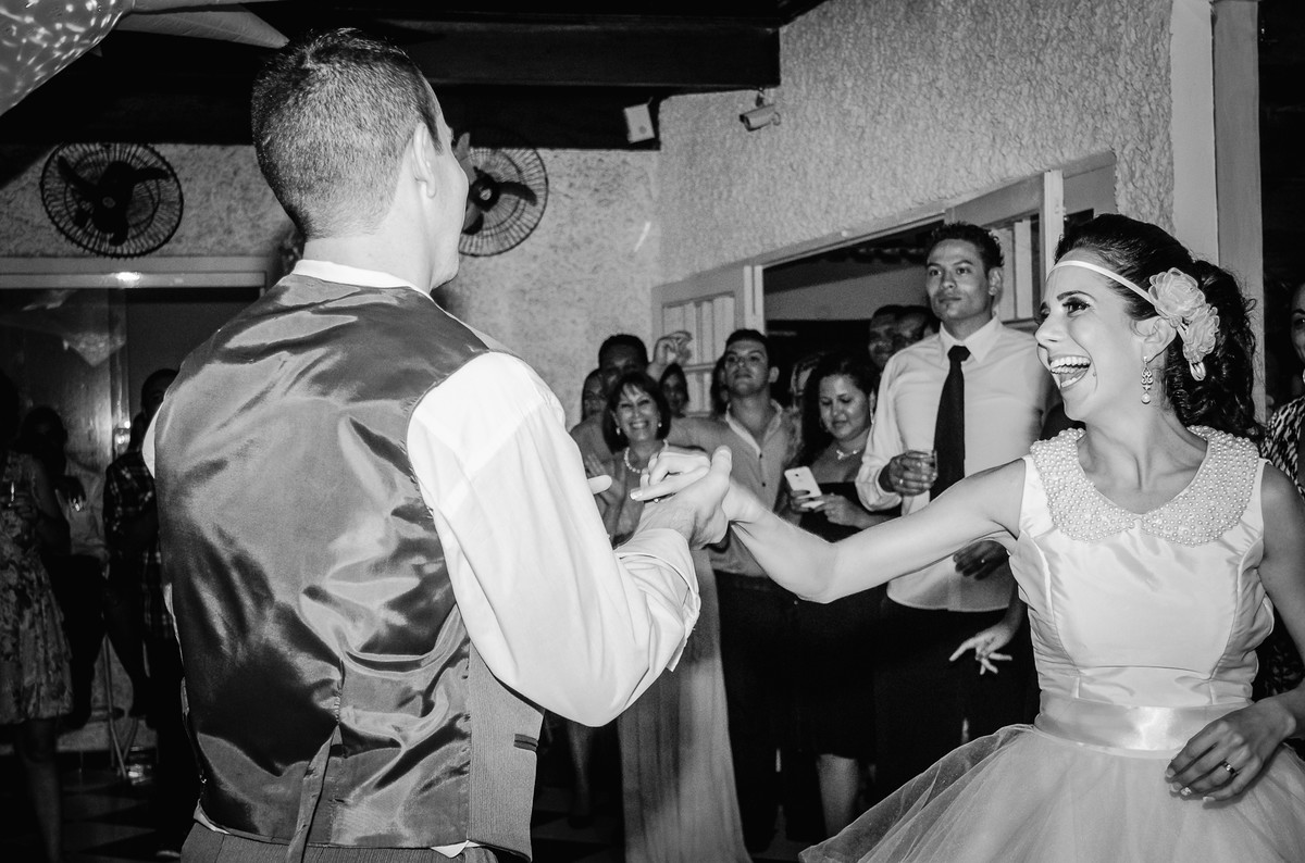Fotografia da dança dos noivos sorrindo durante a festa de casamento no Buffet Laranja em Mongaguá - Cia P&B - Fotografia