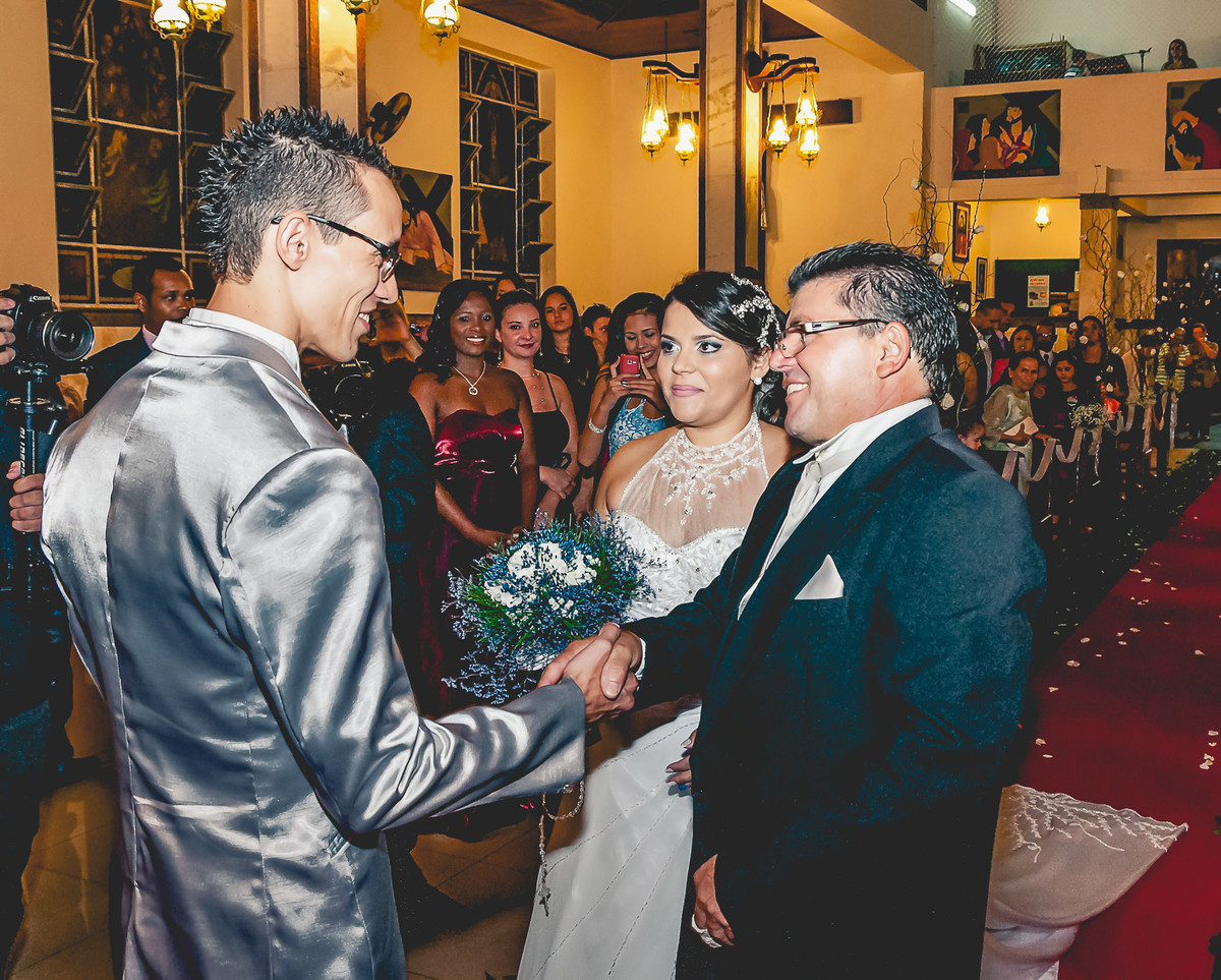 Fotografia do pai entregando a noiva para o noivo durante o casamento na igreja Paróquia Nossa Senhora Aparecida em Mongaguá - Cia P&B - Fotografia