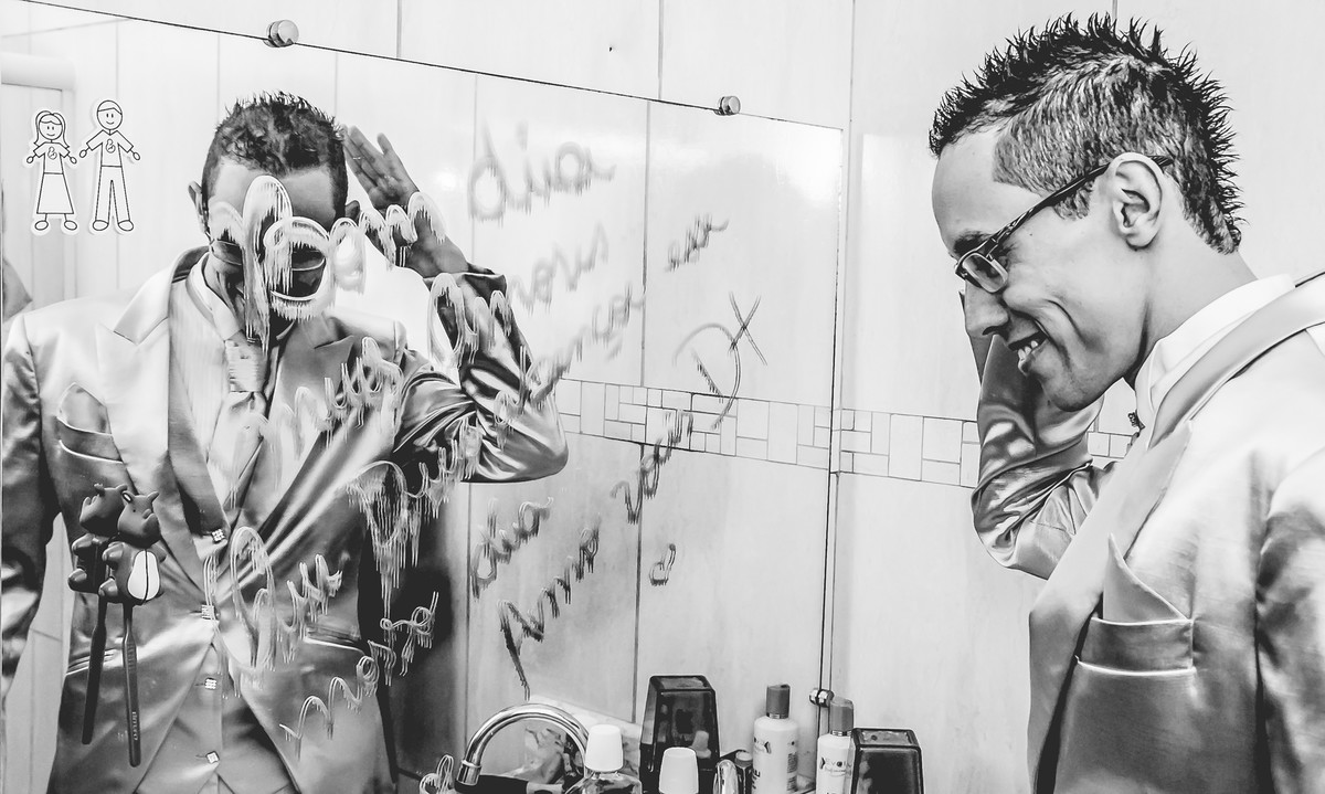 Fotografia do noivo com reflexo no espelho com recado da noiva durante o making of antes do casamento em Mongaguá  - Cia P&B - Fotografia 