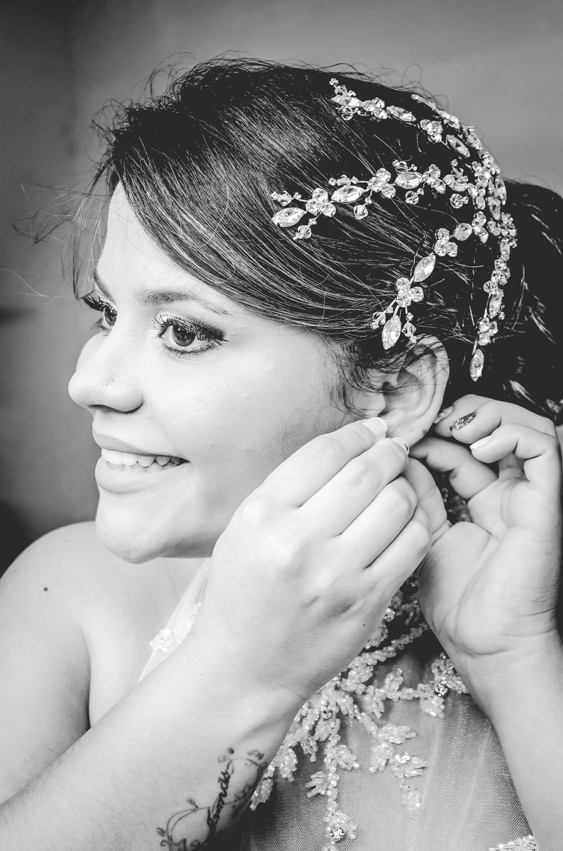 Fotografia da noiva colocando o brinco durante o making of antes do casamento no salão Driely Designers em Mongaguá - Cia P&B - Fotografia 