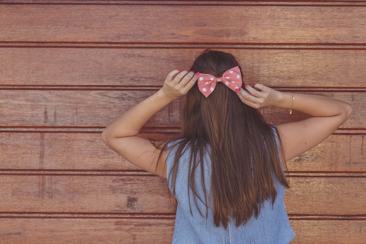 Fotografia da blogueira Fofuras da Ka mostrando detalhe do laço no cabelo durante ensaio fotográfico em Itanhaém - Cia P&B - Fotografia