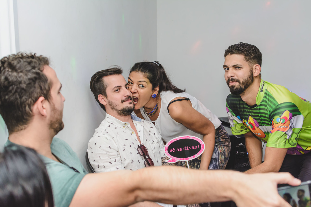 Fotografia de convidados brincando com as plaquinhas com mensagem durante a festa de aniversário 