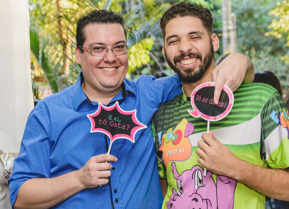 Fotografia do pai da Ana Julia com amigo sorrindo e mostrando plaquinhas de mensagem durante a festa de aniversário de 5 anos em São Paulo - Cia P&B - Fotografia