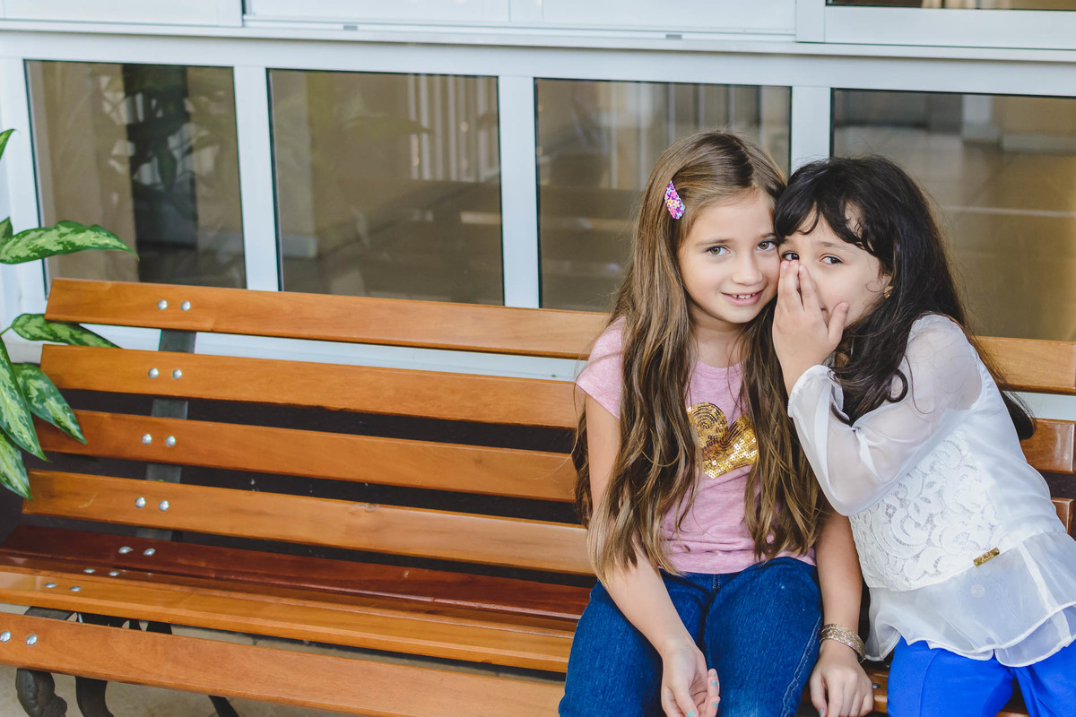 Fotografia da Ana Julia cochichando no ouvido da amiguinha durante a festa infantil de 5 anos em São Paulo - Cia P&B - Fotografia