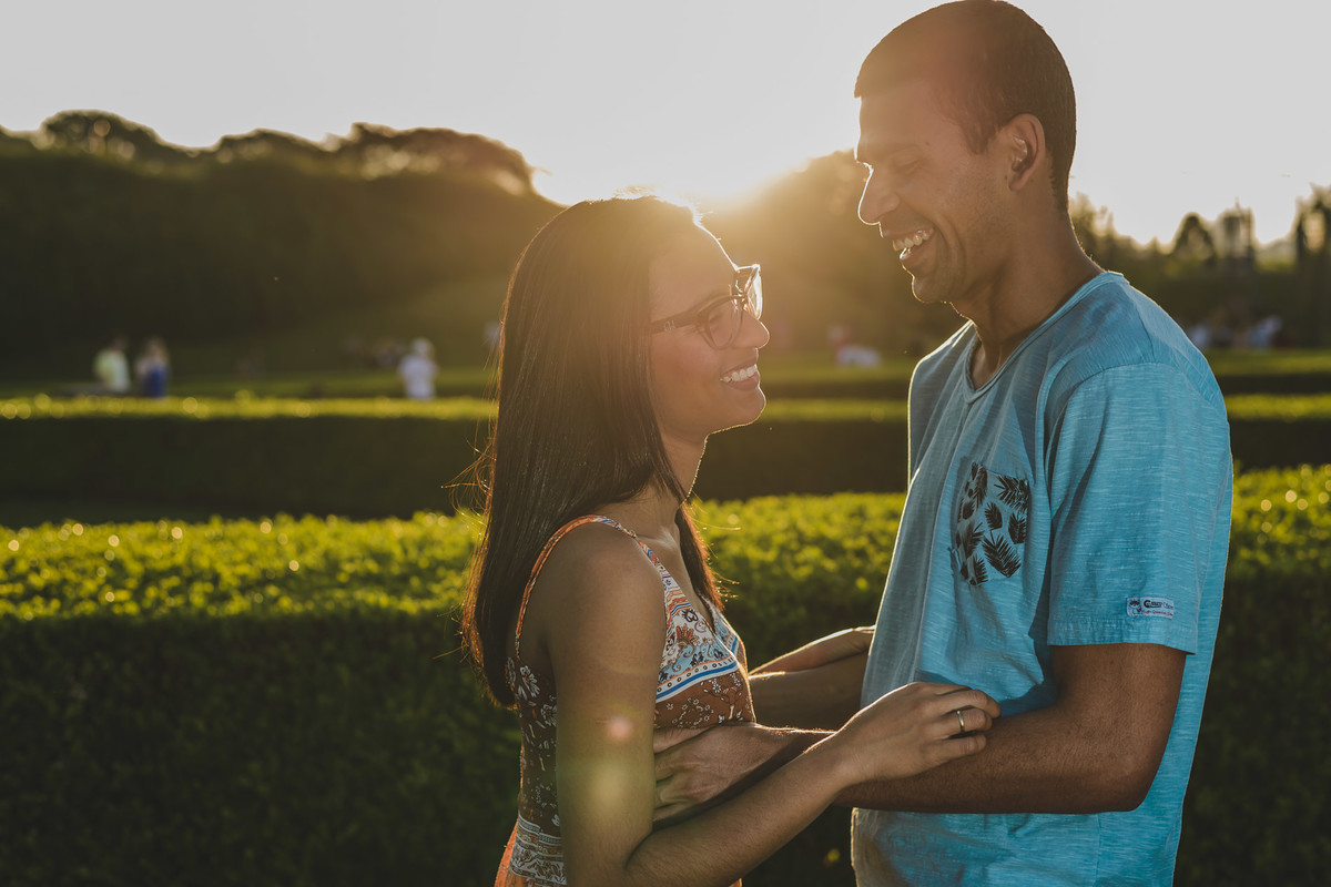 Foto dos Noivos se olhando e sorrindo com o pôr do sol no jardim francês no ensaio pré wedding - Jardim Botânico - Curitiba - fotografia Cia P&B Produções 