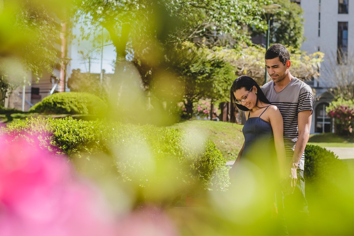 Foto dos noivos de mãos dadas no jardim da praça Japão com moldura de folhas e flores - Curitiba - fotografia Cia P&B Produções 