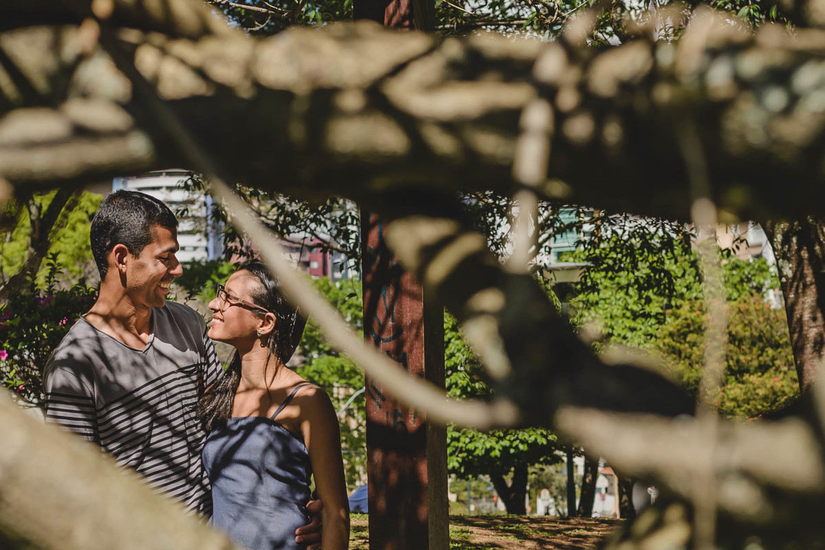 Foto dos Noivos se olhando e sorrindo entre os galhos na praça Japão no ensaio pré wedding - Curitiba - fotografia Cia P&B Produções 
