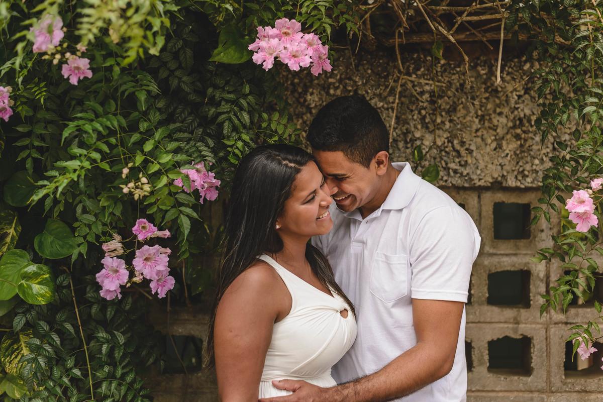 Foto dos noivos sorrindo com o rosto colado e uma moldura de flores em volta no ensaio pré wedding - Itanhaém - SP - fotografia Cia P&B Produções