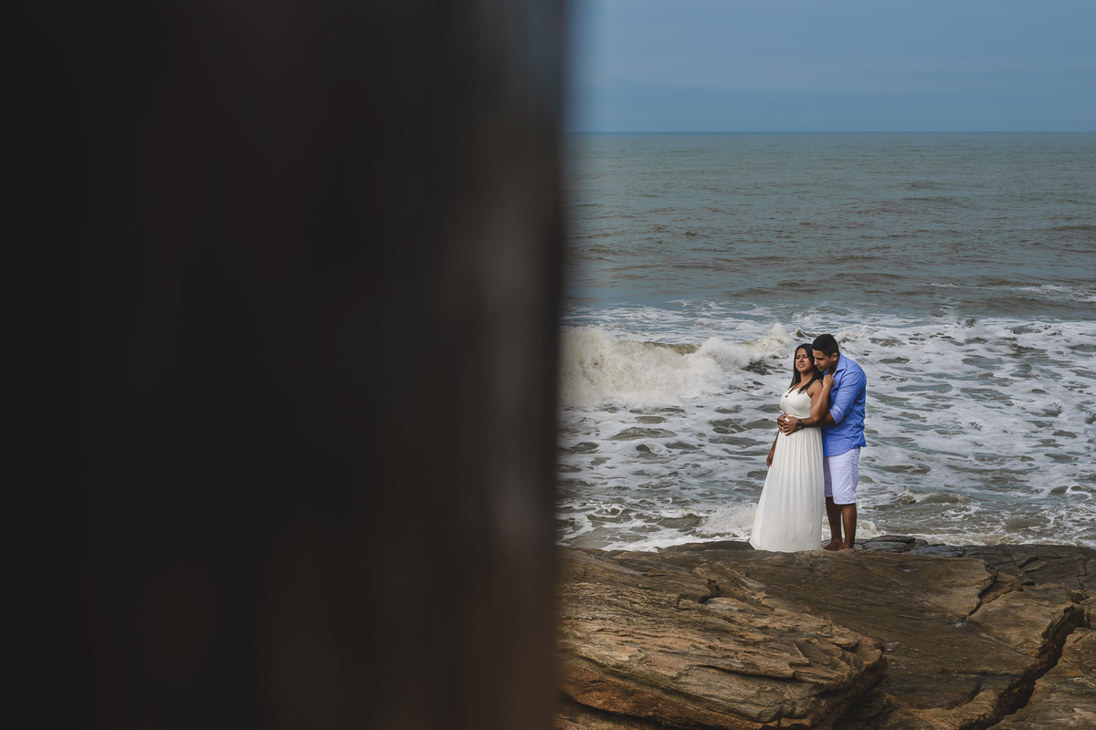 Foto dos Noivos nas pedras se abraçando com o mar ao fundo no ensaio pré wedding - Itanhaém - SP - fotografia Cia P&B Produções