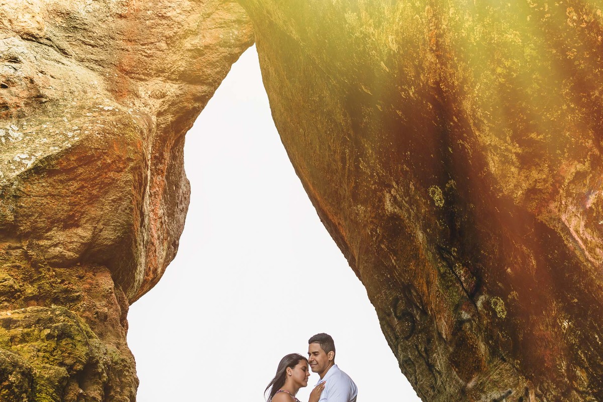 Foto dos Noivos abraçados embaixo da pedra principal do morro de Paranambuco no ensaio pré wedding - Itanhaém - SP - fotografia Cia P&B Produções