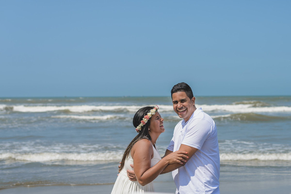Foto do casal rindo e brincando na praia durante o ensaio pré wedding em Itanhaém na praia dos Pescadores - Cia P&B - Fotografia