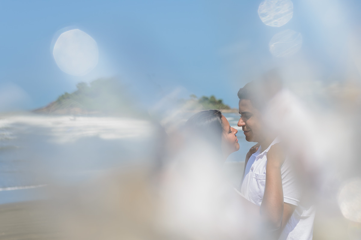 Foto da Noiva e noivo abraçados se olhando e sorrindo na praia dos Pescadores com efeito criativo no ensaio pré wedding - Itanhaém - SP - fotografia Cia P&B Produções