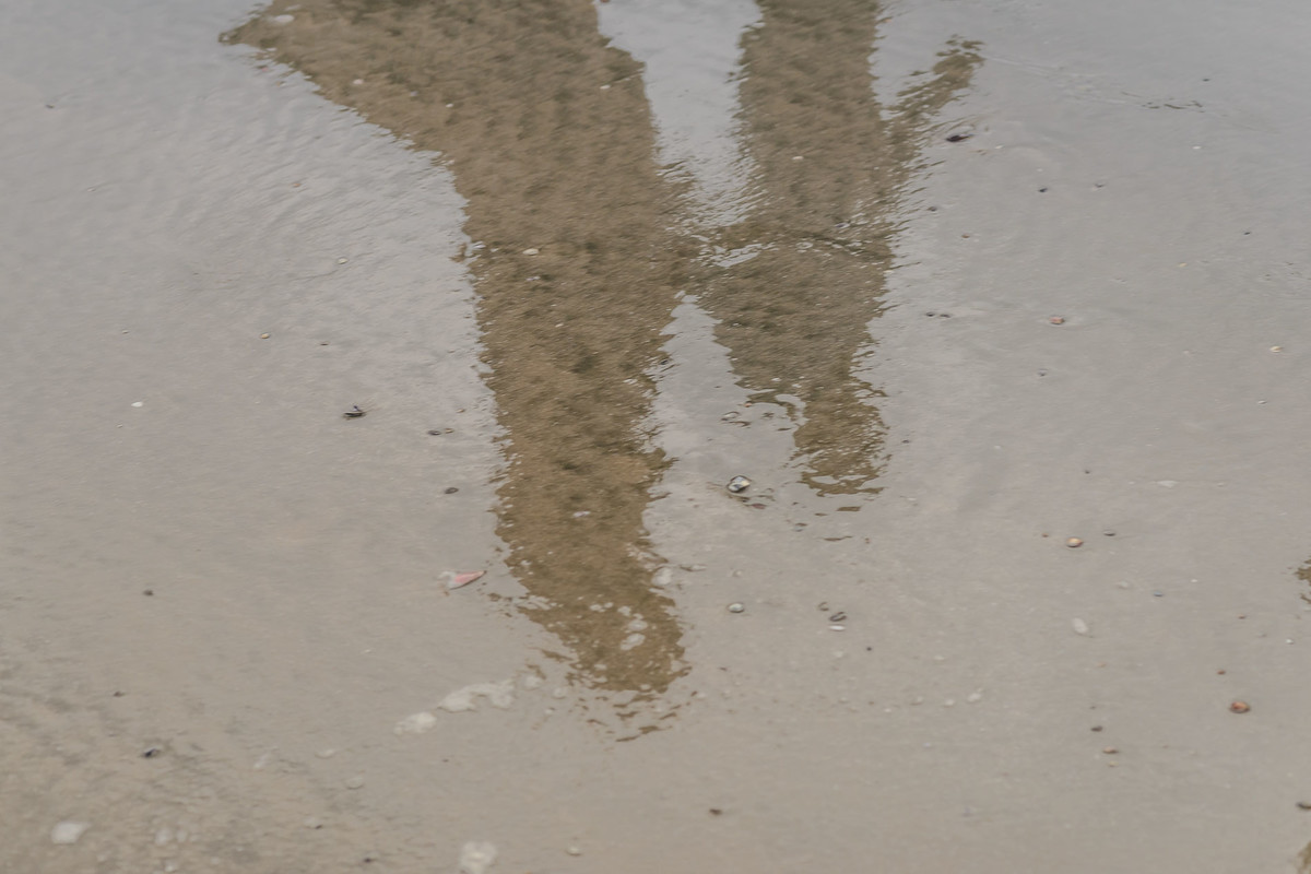 foto do reflexo dos noivos caminhando na praia - Itanhaém - SP - fotografia Cia P&B Produções 