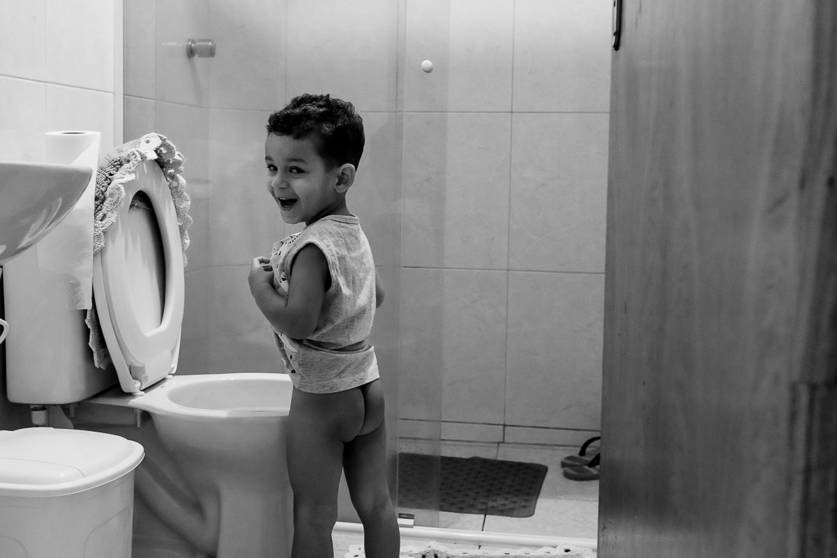 Ensaio de família registrando momentos únicos durante a criança indo fazer xixi na cidade São josé dos Pinhais no Paraná
