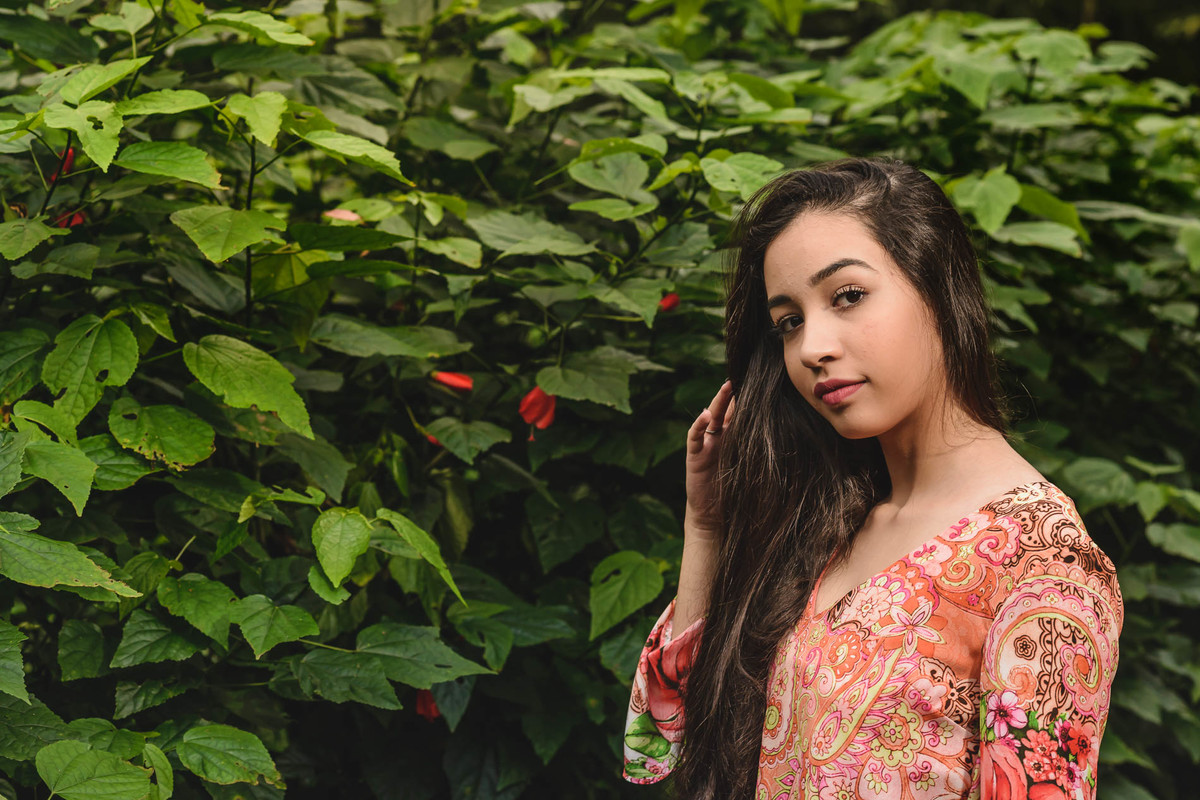 Ensaio de 15 anos retrato da debutante com folhagem e flores ao fundo - Poço das Antas - Mongaguá - SP - fotografia Cia P&B