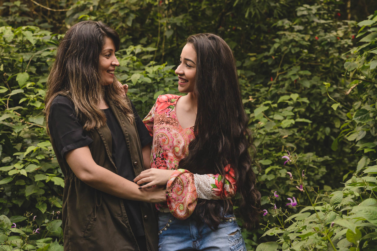 Ensaio de 15 anos debutante e sua mãe sorrindo abraçadas no bosque de árvores - Poço das Antas - Mongaguá - SP - fotografia Cia P&B