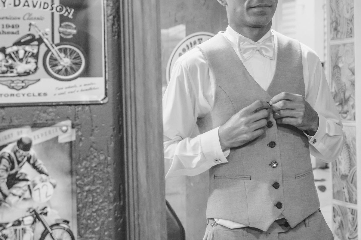 Foto do Noivo fechando o colete no espelho - making of do noivo - Mongaguá - Sp- fotografia Cia P&B Produções