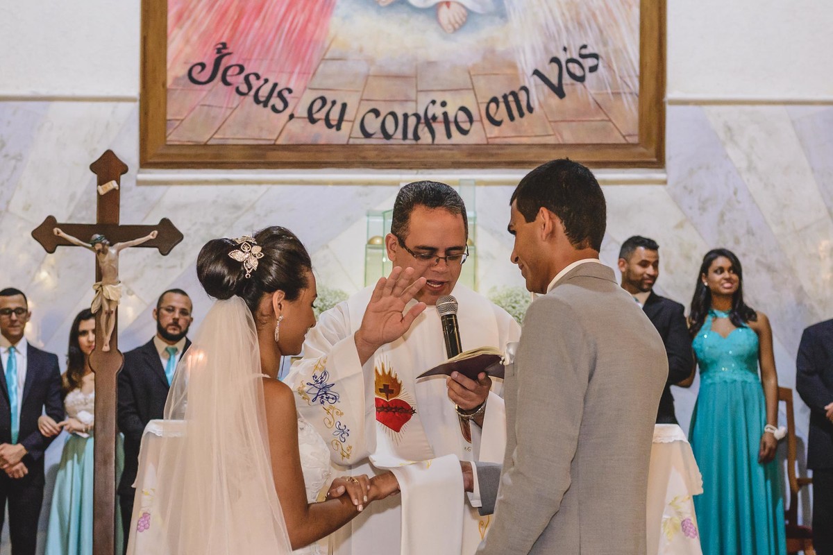 Foto do Padre abençoando a união do casal durante a cerimônia - Mongaguá - Sp- fotografia Cia P&B Produções