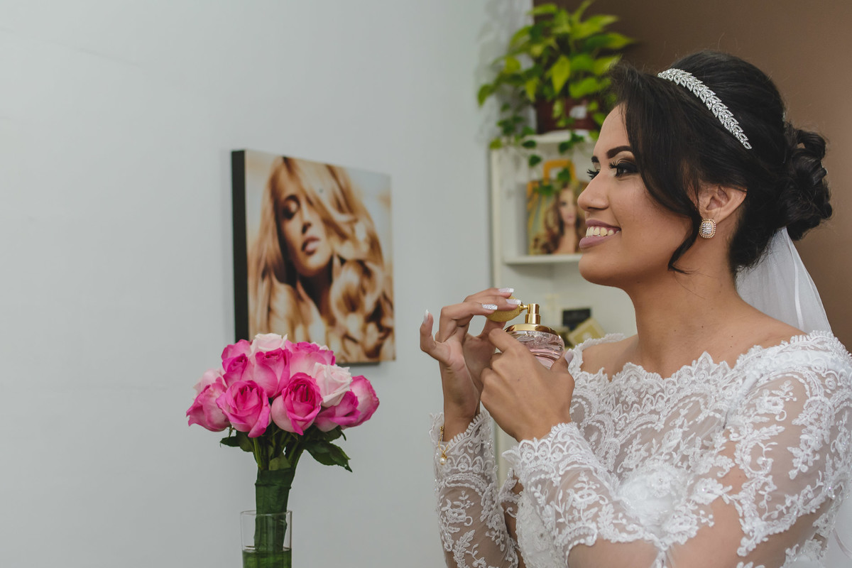 Noiva de perfil passando perfume e sorrindo no making of em Praia Grande - SP - fotografia Cia P&B Produções 