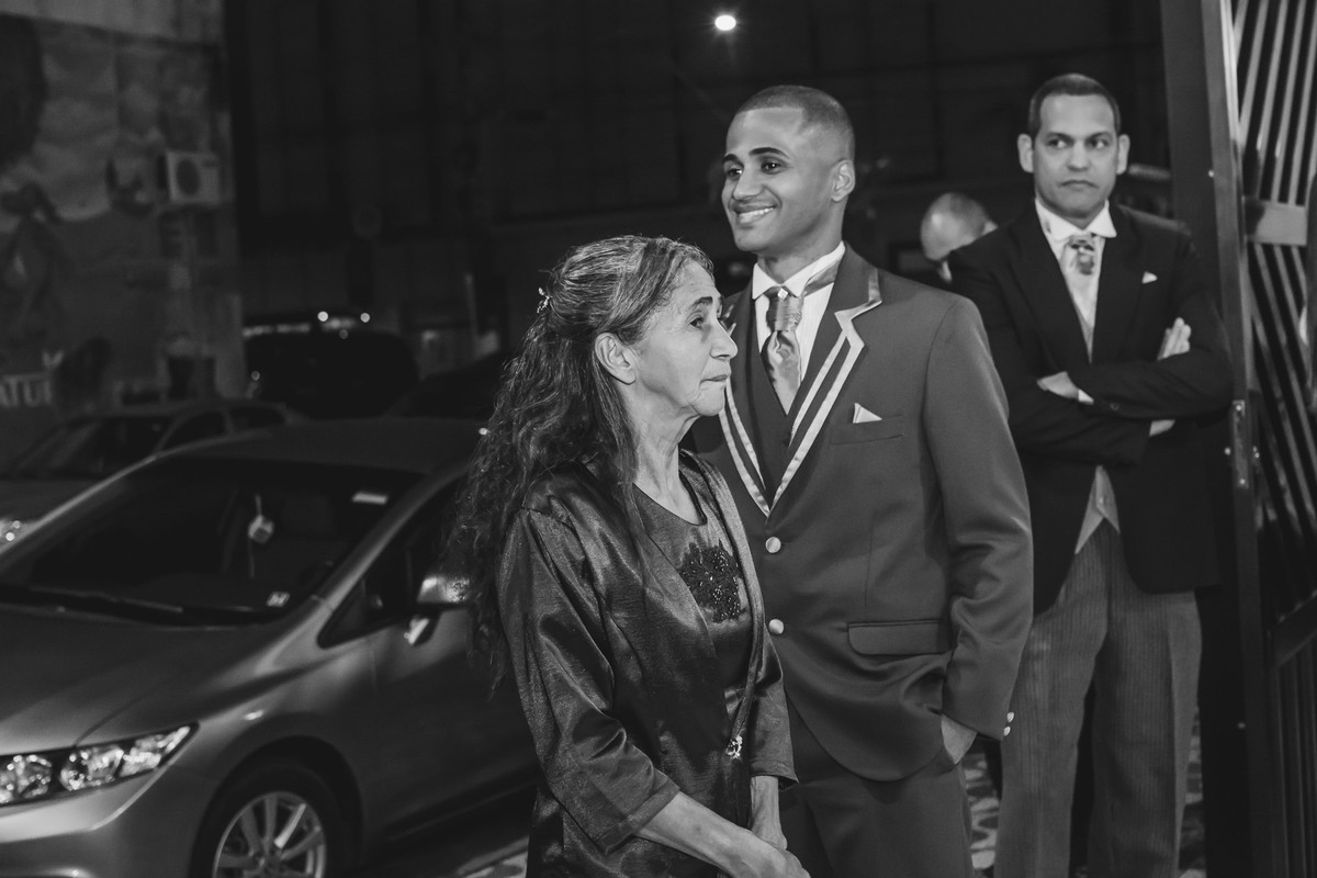 Noivo sorrindo com sua mãe na porta da igreja esperando a noiva em Praia Grande - SP - fotografia Cia P&B Produções 