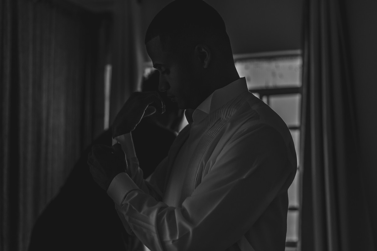 Noivo fechando o botão da camisa no making of no dia do casamento em Praia Grande - SP - fotografia Cia P&B Produções 
