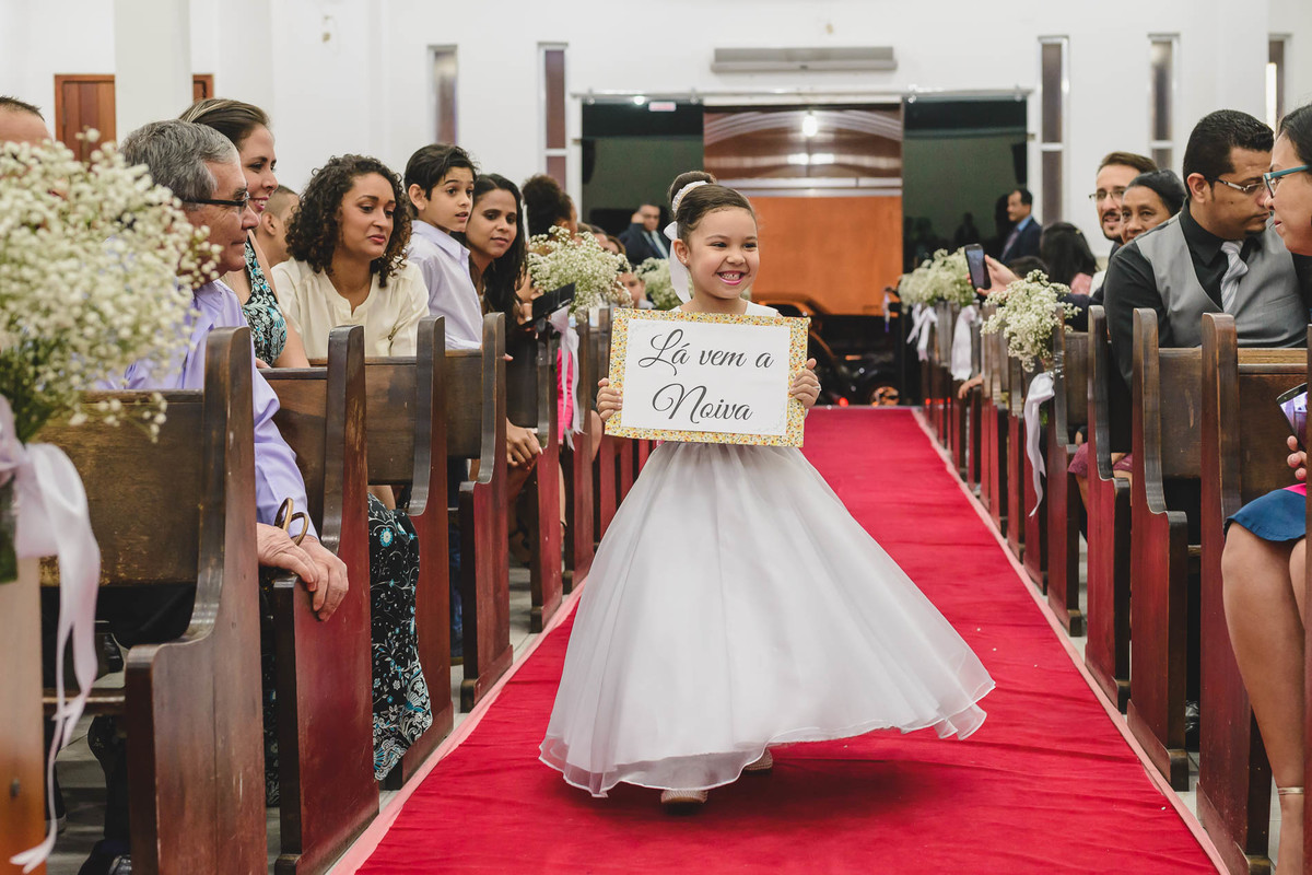Entrada da daminha sorrindo com a plaquinha 